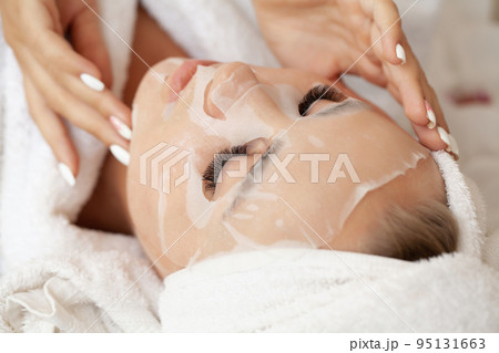 Young woman with cloth mask at spa salon 95131663