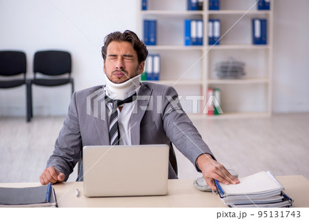 Young male employee after car accident working in the office Young male employee after car accident working in the office 95131743