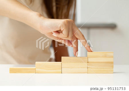 Hand arranging wood cube stacking as step stair. Hand arranging wood cube stacking as step stair. 95131753