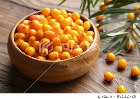 Wooden bowl of ripe sea buckthorn berries. Wooden bowl of ripe sea buckthorn berries. 95132739
