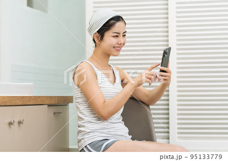 洗面所でスマホを見る女性 洗面所でスマホを見る女性 95133779