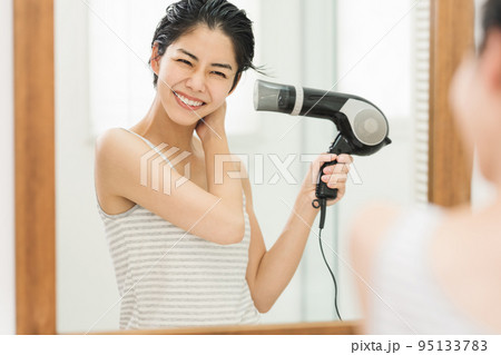 お風呂上がりに髪をドライヤーで乾かす女性 95133783