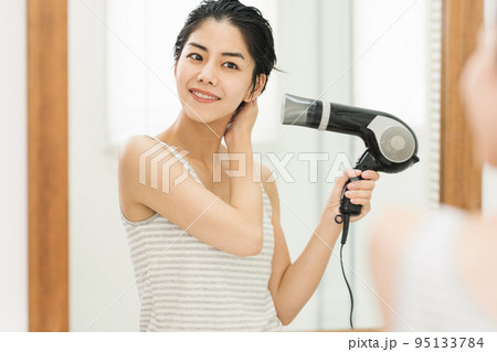 お風呂上がりに髪をドライヤーで乾かす女性 95133784