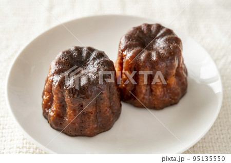 白いお皿にのったフランスの洋菓子カヌレ 95135550