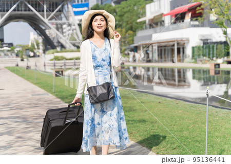 スーツケースを引いて名古屋観光をする若い女性 95136441