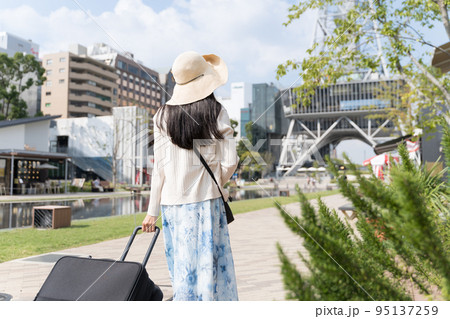 スーツケースを引いて名古屋観光をする若い女性 後ろ姿 スーツケースを引いて名古屋観光をする若い女性 後ろ姿 95137259
