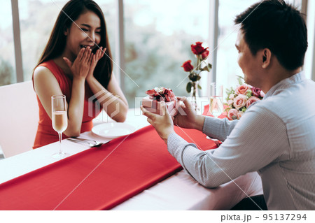 Man couple hand hold a romantic present red gift box give it to girlfriend. 95137294