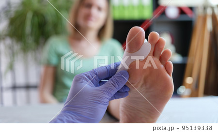 Orthopedist applying brace for hallux valgus for female patient Orthopedist applying brace for hallux valgus for female patient 95139338