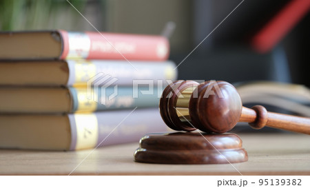 Judge gavel on wooden sounding block and pile of law books Judge gavel on wooden sounding block and pile of law books 95139382