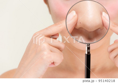 ルーペで女性の鼻を拡大している。 95140218