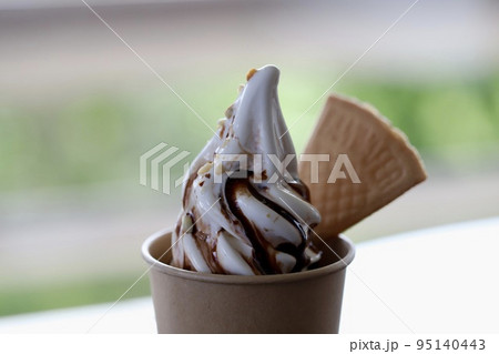 チョコレートソースがかかったカップ入りのバニラソフトクリーム 95140443