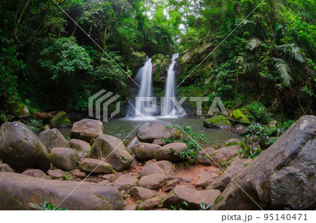 Beautiful woman in red dress in front of the Sapan Waterfall, Khun Nan National Park, Boklua District, Nan Province, Thailand. 95140471