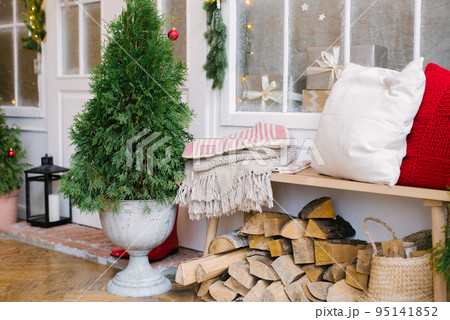 Christmas comfort in the house, Christmas tree, pillows on a wooden bench, blanket 95141852