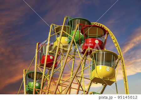 Attraction (carousel) ferris wheel against the background of a romantic evening sky Attraction (carousel) ferris wheel against the background of a romantic evening sky 95145012