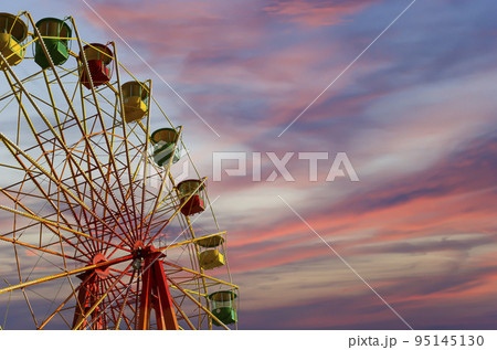 Attraction (carousel) ferris wheel against the background of a romantic evening sky Attraction (carousel) ferris wheel against the background of a romantic evening sky 95145130