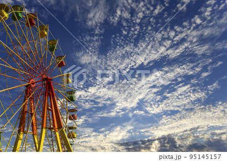 Attraction (carousel) ferris wheel on the background of the cloudy sky Attraction (carousel) ferris wheel on the background of the cloudy sky 95145157