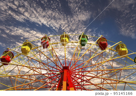 Attraction (carousel) ferris wheel against the background of a romantic evening sky Attraction (carousel) ferris wheel against the background of a romantic evening sky 95145166