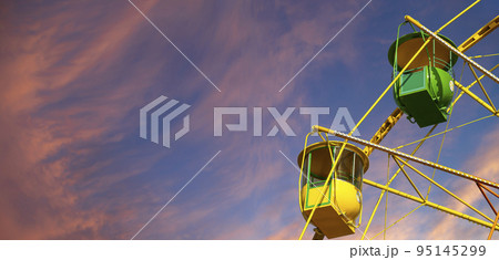 Attraction (carousel) ferris wheel against the background of a romantic evening sky Attraction (carousel) ferris wheel against the background of a romantic evening sky 95145299