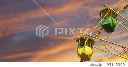 Attraction (carousel) ferris wheel against the background of a romantic evening sky Attraction (carousel) ferris wheel against the background of a romantic evening sky 95145300
