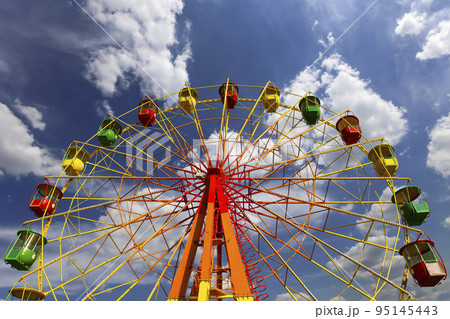 Attraction (carousel) ferris wheel on the background of the cloudy sky Attraction (carousel) ferris wheel on the background of the cloudy sky 95145443