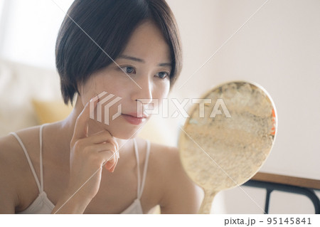 肌荒れに悩む手鏡を持つ女性 肌荒れに悩む手鏡を持つ女性 95145841