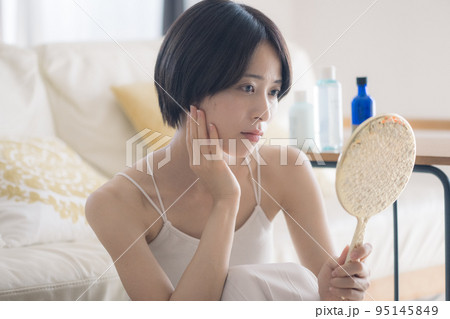 肌荒れに悩む手鏡を持つ女性 肌荒れに悩む手鏡を持つ女性 95145849