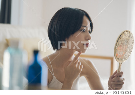 肌荒れに悩む手鏡を持つ女性 肌荒れに悩む手鏡を持つ女性 95145851