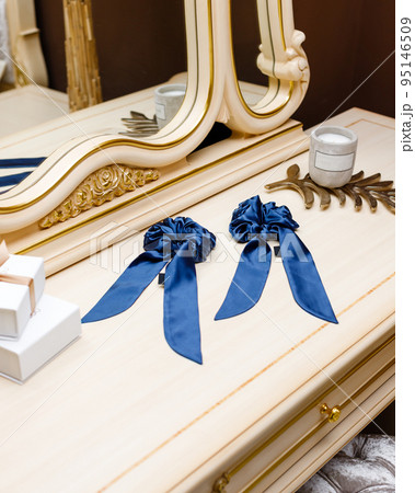Exquisite women's blue handmade silk scrunchy lie on table among luxury interior details. 95146509