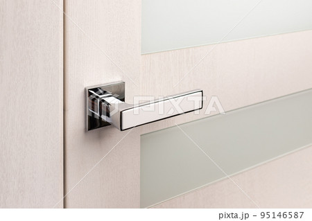 Close up of beautiful and stylish new metal door knob on modern interior door. Close up of beautiful and stylish new metal door knob on modern interior door. 95146587