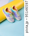 Close up of trendy colored sneakers for teenage girls on colorful yellow-blue background. 95146597