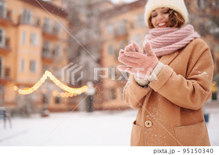 Young woman in winter style clothes posing at festive street market. Cold weather. Winter fashion, holidays. Young woman in winter style clothes posing at festive street market. Cold weather. Winter fashion, holidays. 95150340