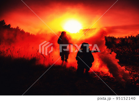 United States Marines in action. Military action, desert battlefield, smoke grenades., fire and explosions. Sun setting, dark silhouettes in the desert 95152140