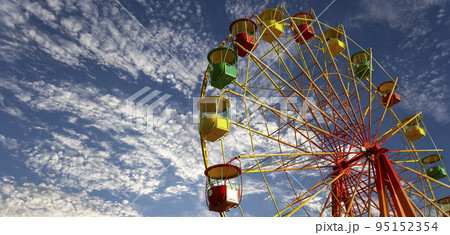 Attraction (carousel) ferris wheel on the background of the cloudy sky 95152354