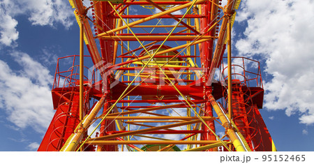 Attraction (carousel) ferris wheel on the background of the cloudy sky Attraction (carousel) ferris wheel on the background of the cloudy sky 95152465
