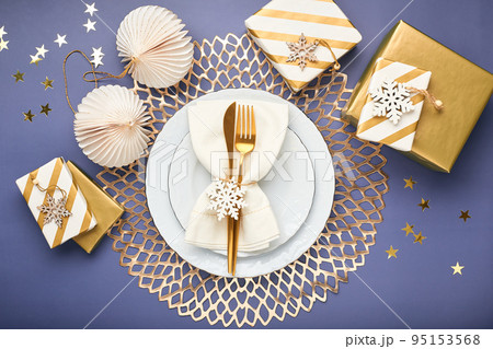 Christmas festive table setting with white plates and gold cutlery. Flatlay, in blue and gold colors 95153568