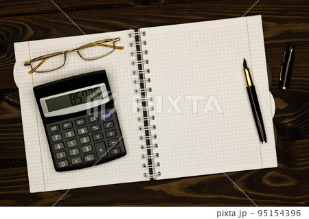 Top view office table desk. Financial report. Flat lay. Workspace with Business office supplies, empty sheet of paper, pen, glasses, calculator on the table. Copy space for text. Top view. Close-up 95154396