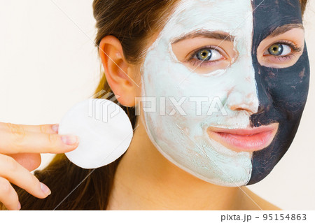 Girl remove black white mud mask from face Girl remove black white mud mask from face 95154863