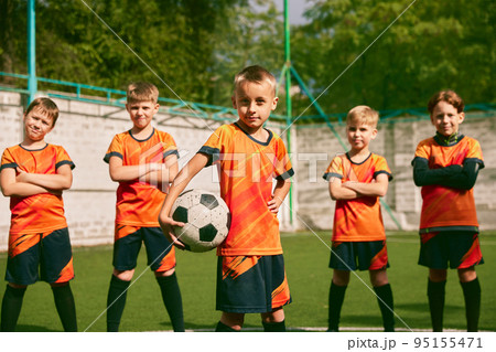 Future football champions. Little boys, kids in sports uniform posing with ball at soccer school stadium. Concept of sport, studying, achievements, success Future football champions. Little boys, kids in sports uniform posing with ball at soccer school stadium. Concept of sport, studying, achievements, success 95155471