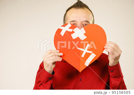 Adult man holding broken heart 95156505