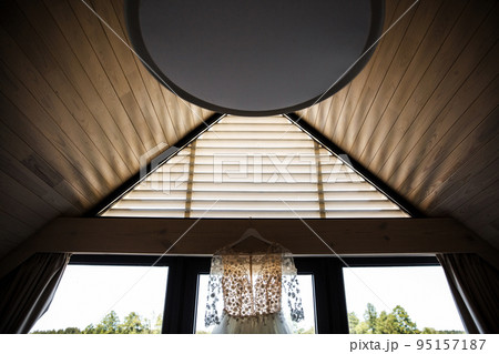 Wedding dress hanging on the window in the room Wedding dress hanging on the window in the room 95157187