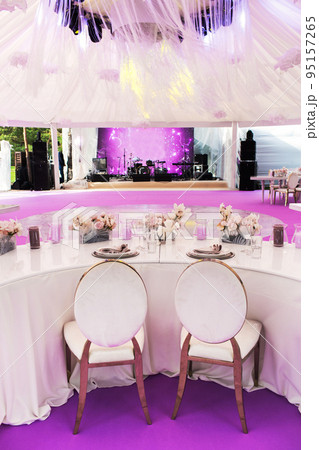 Table set for wedding or another catered event dinner and large paper flowers Table set for wedding or another catered event dinner and large paper flowers 95157265