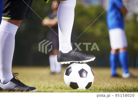 foot of a soccer player stepping on a football ready to kick off a match 95158020
