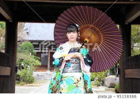白地にターコイズブルー系柄の振袖を着た成人女性、和装ロケーション撮影、成人式 95158366