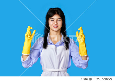 woman in rubber gloves with finger crossed gesture 95159659