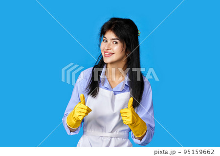 woman in gloves and cleaner apron showing ok sign 95159662