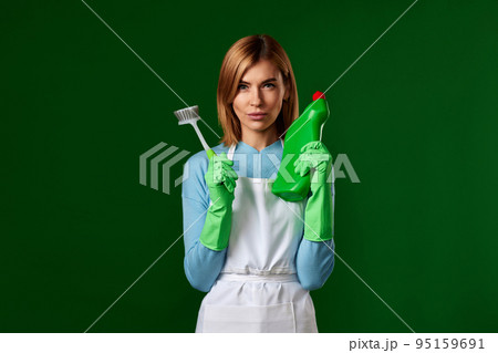 woman in gloves holding brush and bottle of detergent woman in gloves holding brush and bottle of detergent 95159691