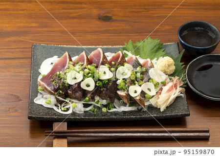 ネギとニンニクをかけた鰹のたたきと日本酒 95159870