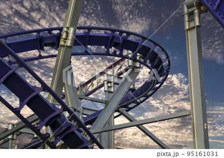 Attraction roller-coaster (switchback) against the background of a romantic evening sky 95161031