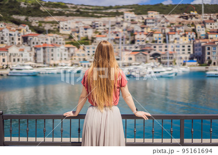 Woman tourist enjoying the views of Architecture and luxury yachts in Lustica Bay, Montenegro. Travel around Montenegro concept. Go Everywhere 95161694