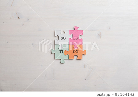 Word Solution spelled with syllables on four matching colorful puzzle pieces 95164142